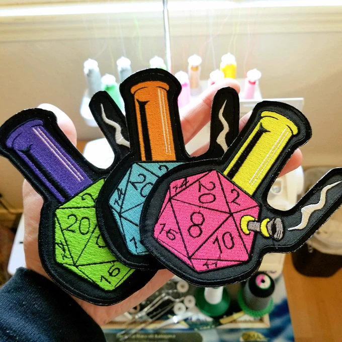 Large embroidered patches in multiple colors of a twenty sided die as a water pipe.