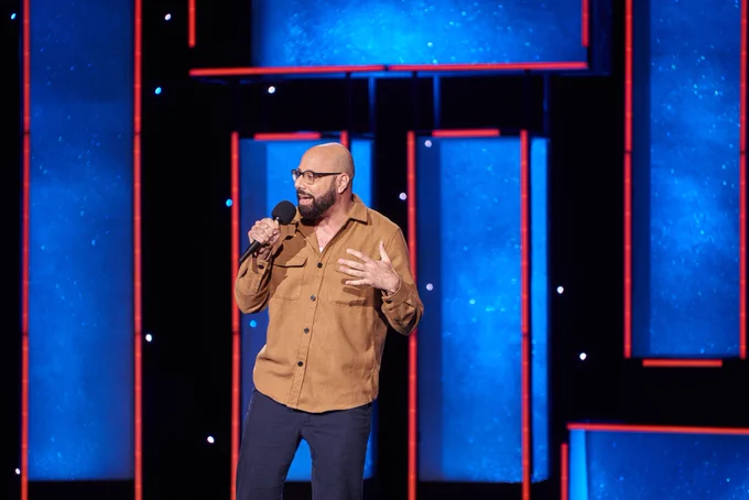 Dave Merheje on stage with a microphone 