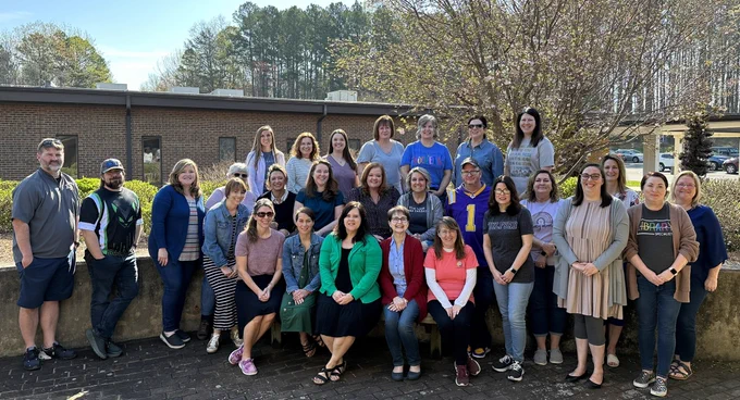 A photo of RCSS media coordinators taken in a courtyard with a springtime budding tree in the background.