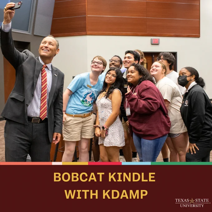 President Damphousse taking a selfie with students and text that reads: Bobcat Kindle with KDamp