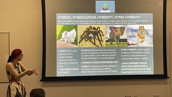 red haired white woman addressing a slide of hybrid animals
