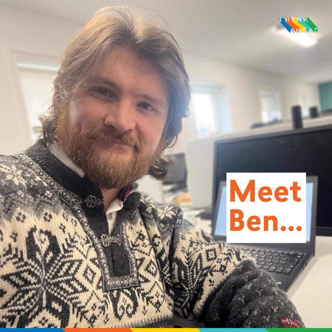 Photo of Ben, Think Ahead trainee mental health social worker, at his desk in the office. 