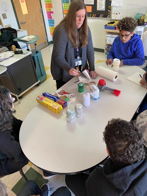 Student’s exploring thermal conductivity and heat transfer with cold sodas wrapped in different materials.