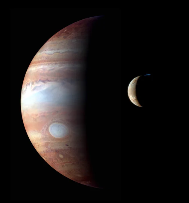Jupiter and its moon Io as seen by NASA's New Horizons spacecraft. Both bodies are seen in a crescent phase against the darkness of space. Jupiter has stripes of swirling, colorful clouds. Smaller Io has a mottled, yellow and orange surface. A small blue glow near Io's north pole is the plume of an erupting volcano.