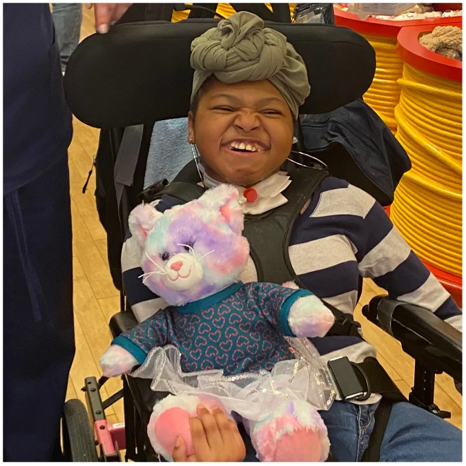 Smiling young girl holding a teddy-bear that looks like a pastel kitty. She  is very happy to show off her new stuffed animal.
