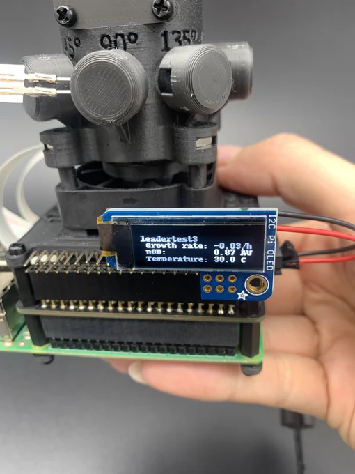 A Pioreactor with an  Adafruit PiOLED display attached. The display gives a growth rate, OD reading and a temperature reading. 