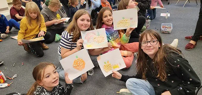 Students pose with a craft they created in class