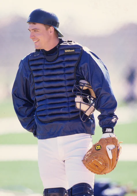 Photo of Dan Wilson smiling while wearing catchers gear during his playing career.