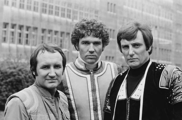 English actors Michael Keating, Steven Pacey and Paul Darrow posed together dressed in character as Vila Restal, Del Tarrant and Kerr Avon during the press reception from the science fiction television series Blake's 7 in London on 11th May 1981. They are all hoping that you will give this crap by @blakes7bot a whirl. 
(Photo by United News/Popperfoto via Getty Images/Getty Images)