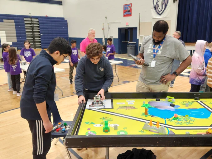 Don Bacon judging two student's RCX presentation. The discussion and feedback is critical to STEM success. 