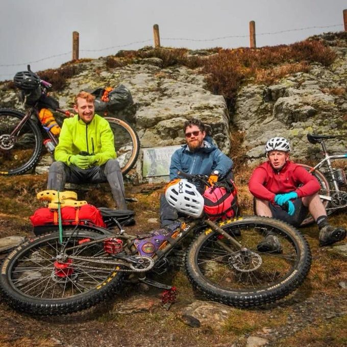 Three Cycling UK staff members at Wayfarer's memorial stone 
