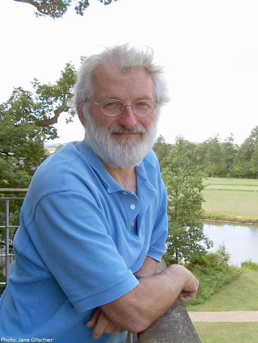 John Sulston standing outdoors leaning on a rail.