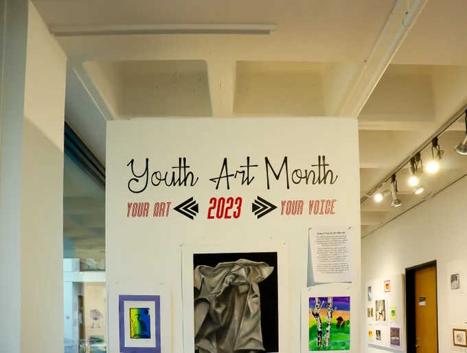 The Youth Art Month 2023 display at the Worcester Art Museumm, with several art pieces and a description of what Youth Art Month is.