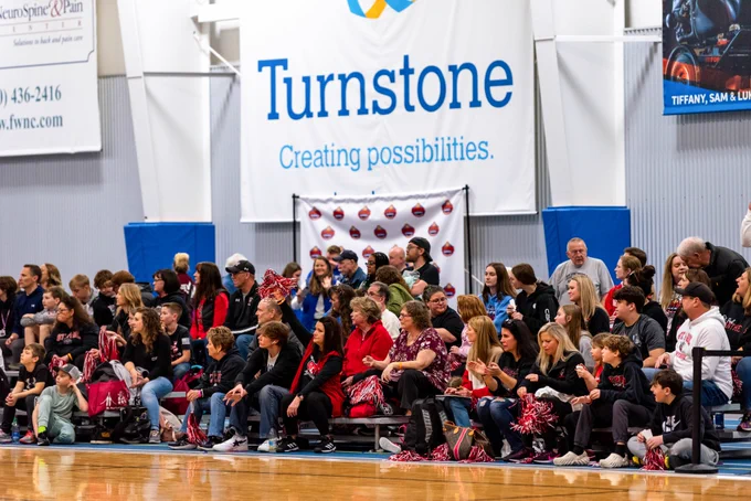 fans cheering on a team a basketball game