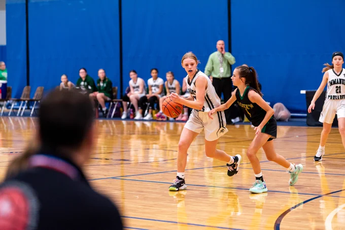 girl dribbling a basketball in a basketball game