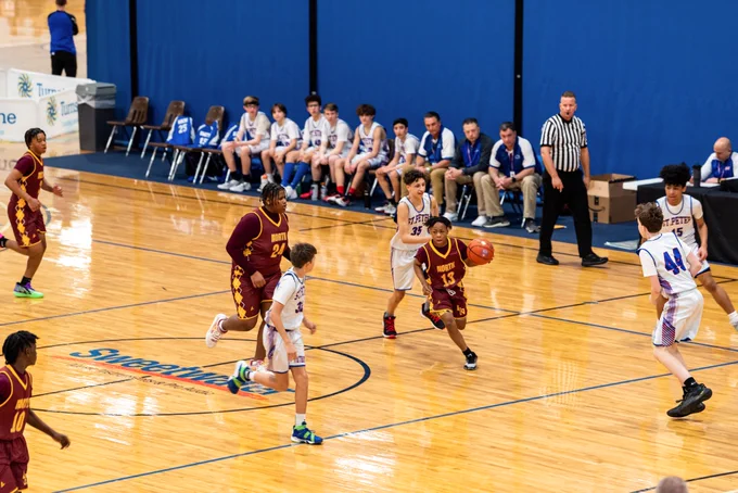 boy dribbling a basketball in a basketball game