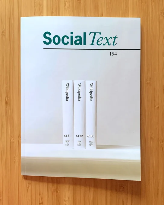 A copy of the journal Social Text on a bamboo table. The cover image is three books from Print WIkipedia.