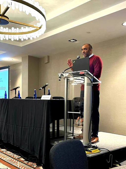 Sudip Parikh stands and speaks at a podium.