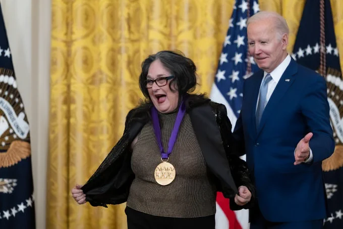 CSUN alumna smiling with her National Medal of Arts alongside President Joe Biden.