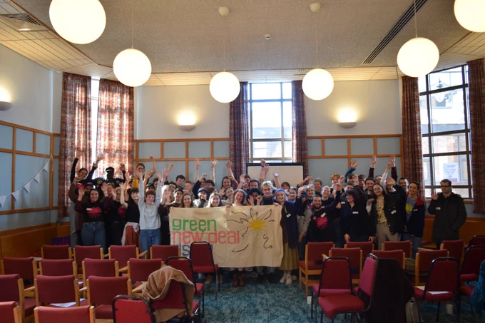 Green New Deal Rising activists holding up a banner.