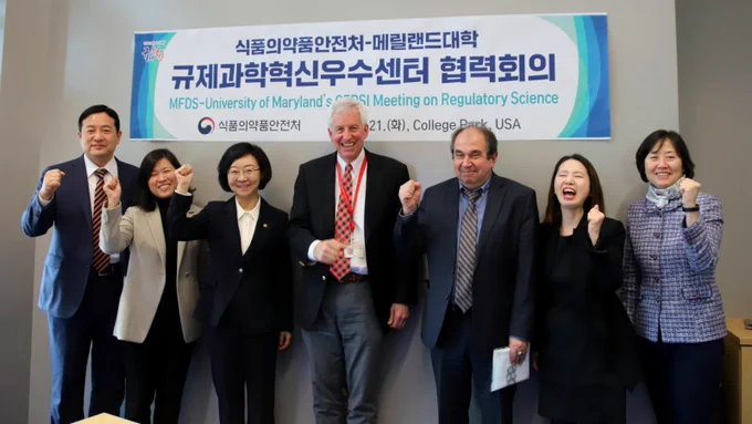 of Dr. Yu-Kyoung Oh, Minister of Korea's Food and Drug Safety and colleagues and Dr. Bill Bentley posing in a group photo together. 