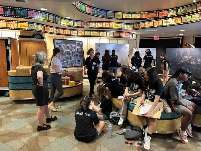 Students working in groups underneath a film strip boarder ceiling