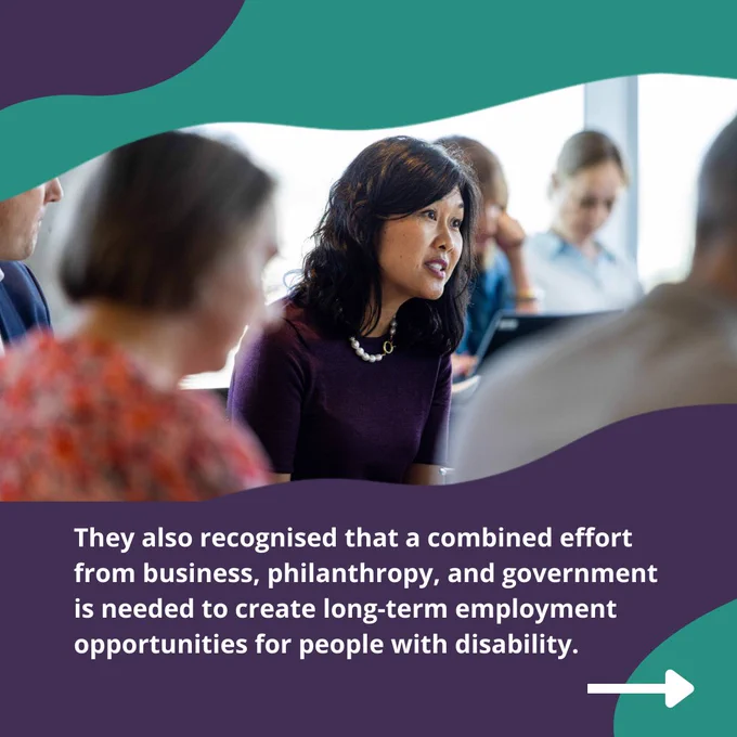 A woman is sitting in a room and talking to a group of people. She has long dark hair and is wearing a purple dress. Text: They also recognised that a combined effort from business, philanthropy, and government is needed to create long term employment opportunities opportunities for people with disability. 