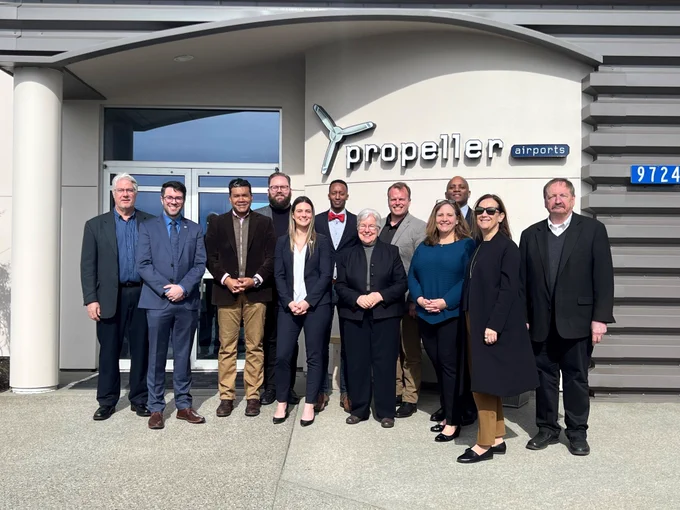 Group photo of SAF press conference speakers and attendees standing in front of Propeller Aero Services.