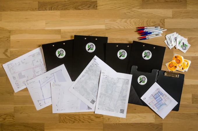 Several Field Papers maps, pens, and clipboards arrayed on a table before a mapping party. Photo by Alexander Kachkaev on Flickr.