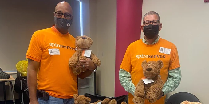 Two Spire Energy volunteers hold teddy bears at the Teddy Bear Clinic. 