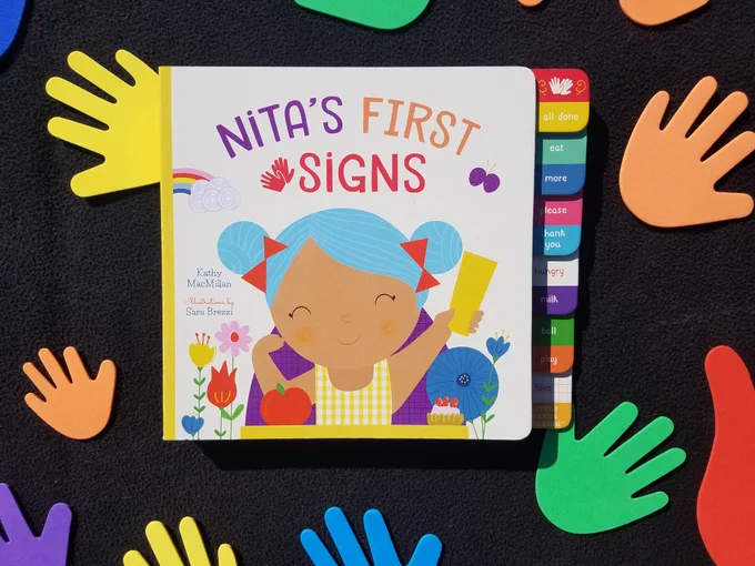 The cover of Nita's First Signs surrounded by colorful hands.