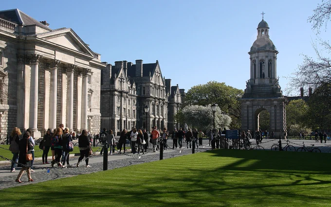 Students walk through Trinity's Front Square with the campanile in the background on a sunny day.