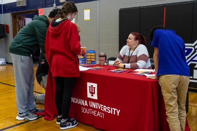 Students talk to an adult at the Indiana University Southeast table.