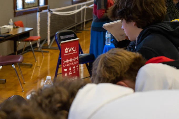 Students stand at a table for WKU.