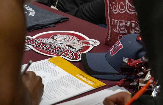 A student fills out a form at the Campbellsville University table.
