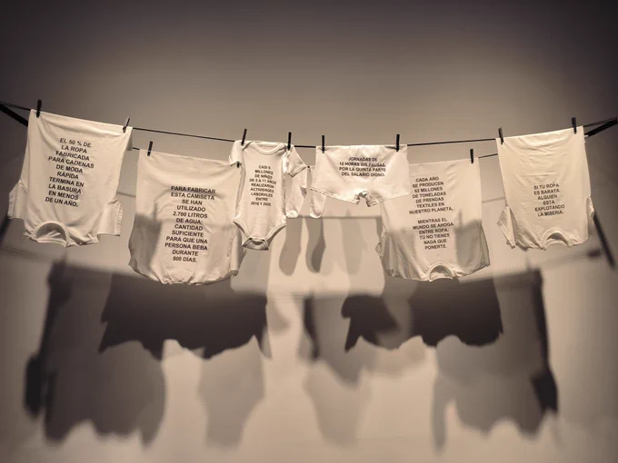 Exposición Social (T)Issues, ropa blanca con datos sobre explotación infantil y uso inadecuado de las prendas.
