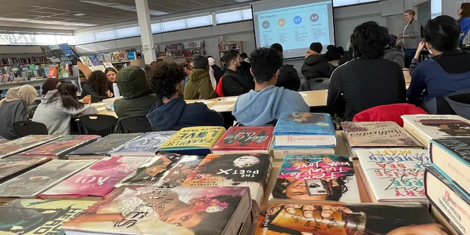 Students during a presentation; books.