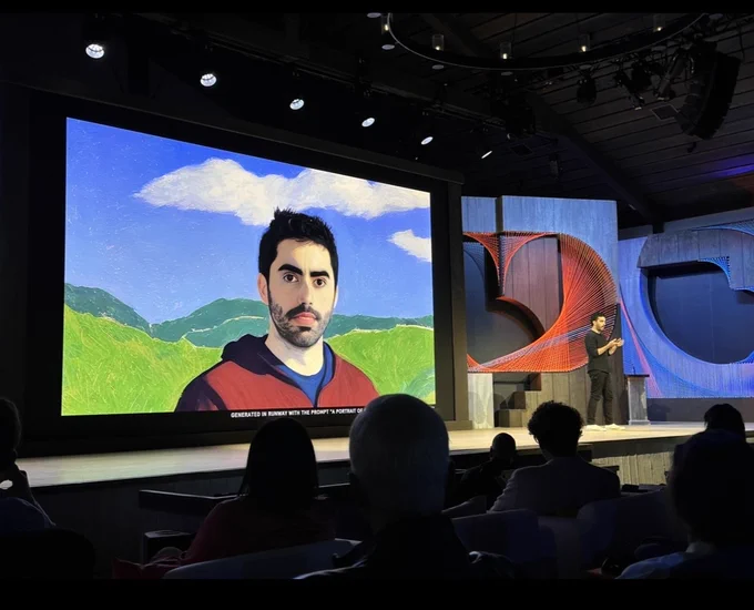A screen with an image of a man shown on stage during a talk about Runway.