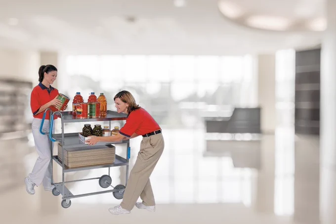 Image of workers putting cans of food and bottle of juice onto a Lakeside utility cart with wheels to be transported