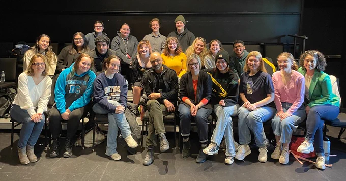 ID: A Group shot with Faran surrounded by Suffolk students and staff.