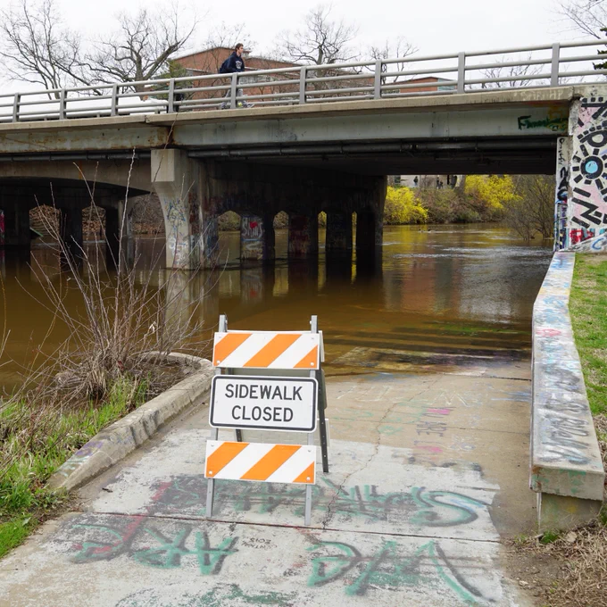 The Farm Lane bridge pedestrian underpass during a previous flood event with sidewalk closure signage.