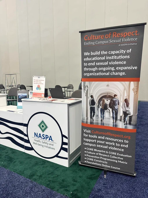 NASPA's Health, Safety and Well-being Initiatives table. Displayed on the table are resources for Culture of Respect, Peer Educator Initiatives, and 360 Proof. Next to the table is Culture of Respect's large pop-up sign. 