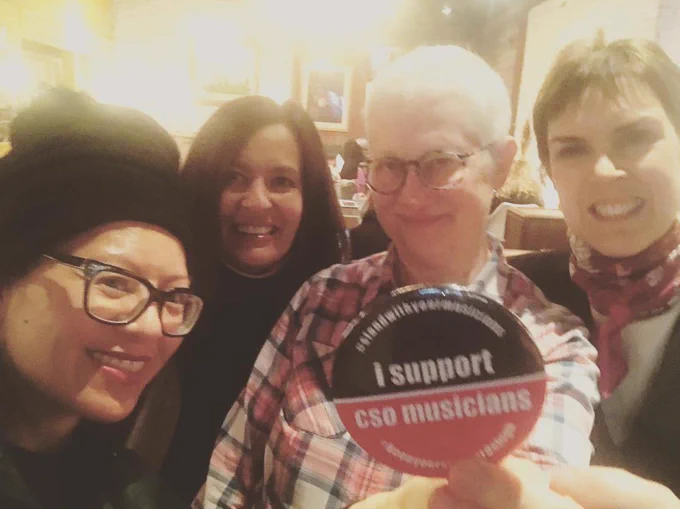Leni holding I support CSO Musicians button for a selfie