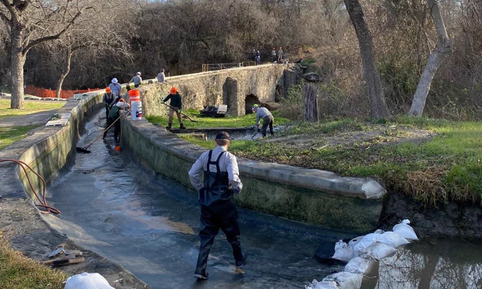 Workers performing preservation, maintenance and repair work on a bridge. 
