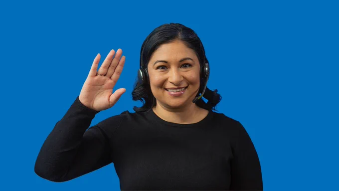 ASL Video Remote Interpreter working and smiling with headset on 