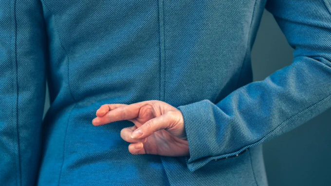 Image of a person crossing their fingers behind their back