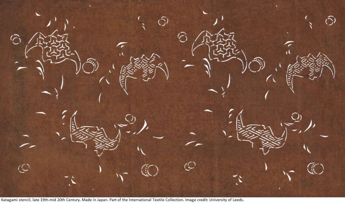 White line drawing of bats flying on a brown background