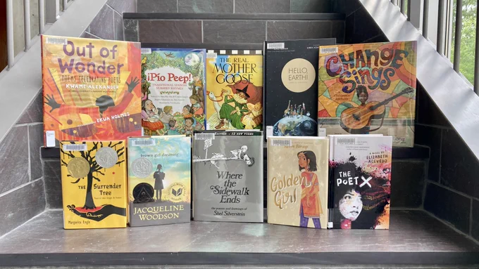 A series of poetry books, all for children and middle grade readers, sit on a large slate staircase.