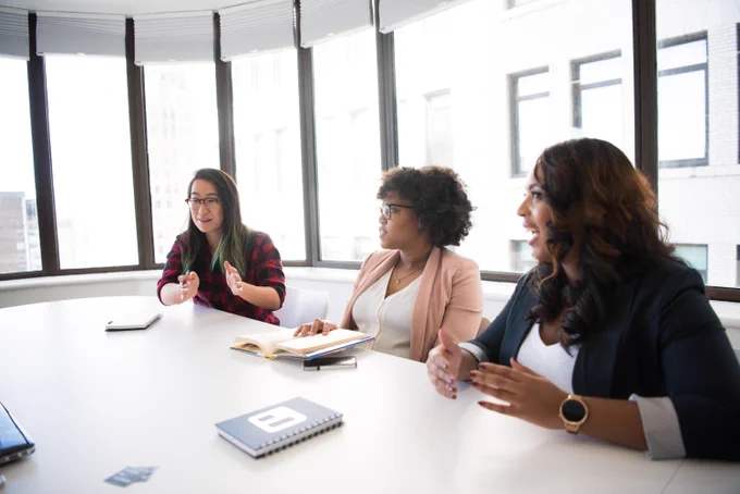 Three people sitting at a conference room table