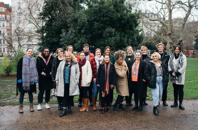 The JB team group together in an urban park. 